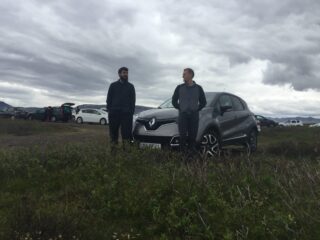 two men and a car in a field