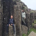 two men standing on rocks