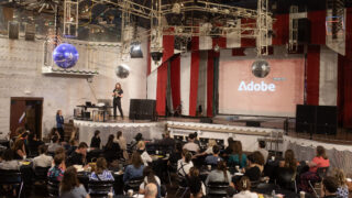 me presenting adobe on stage in front of a large crowd at four star theater