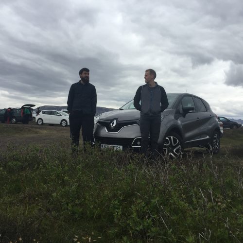 two men and a car in a field