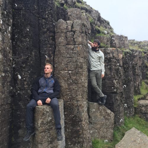 two men standing on rocks